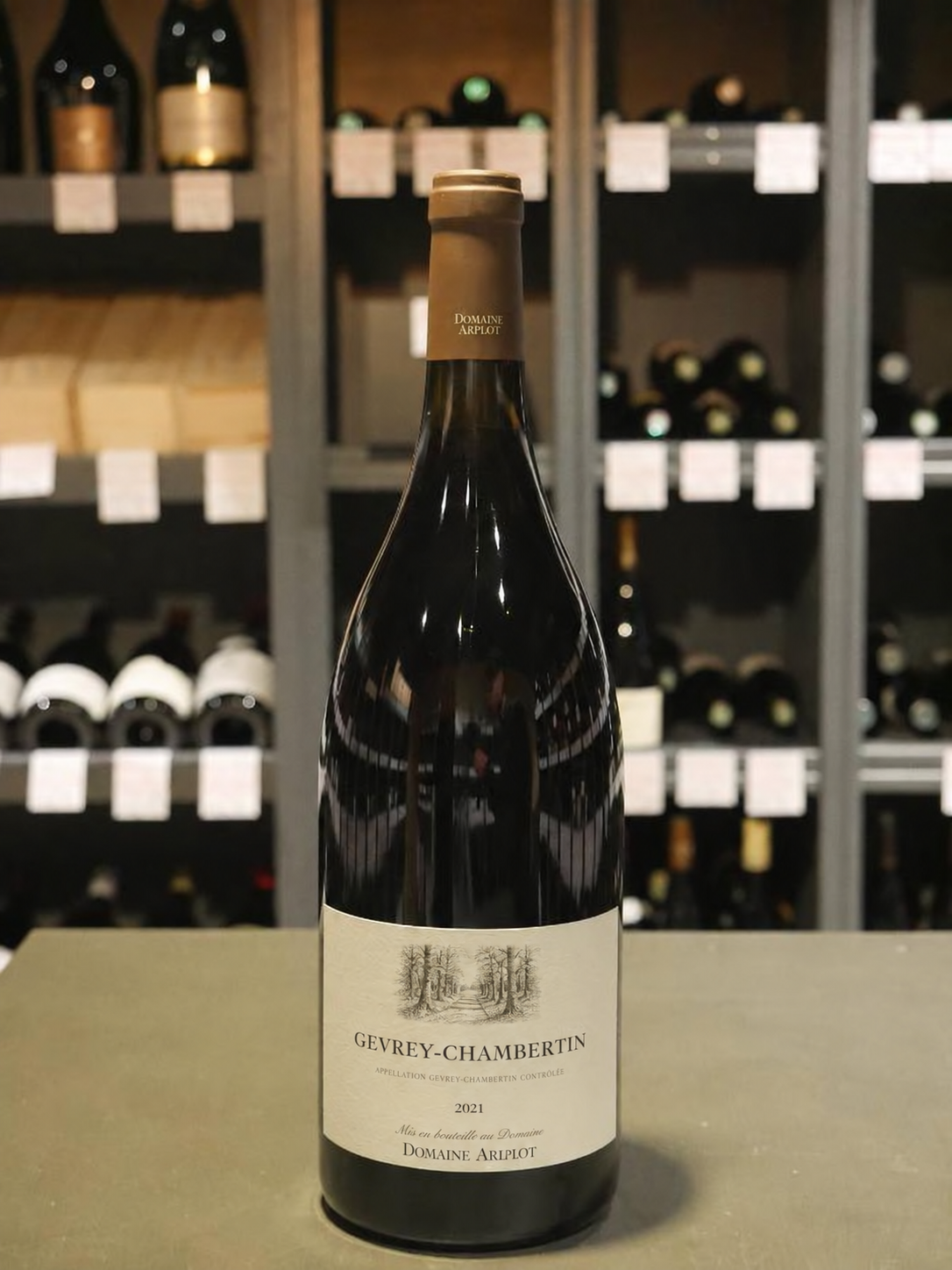 Photo client d’une bouteille de Gevrey-Chambertin du Domaine Arplot, devant les étagères d’une cave